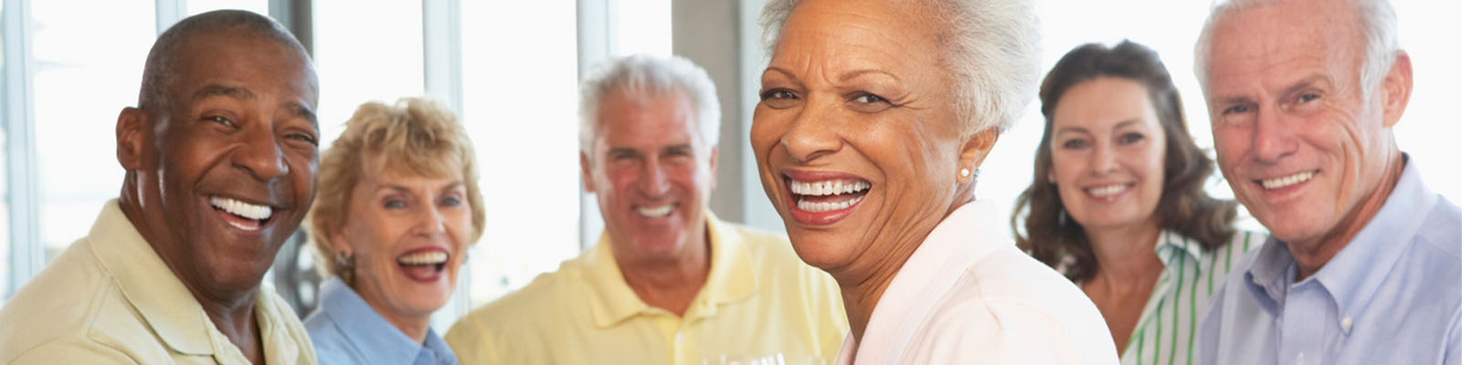 A group of senior living residents sitting together at a table and smiling